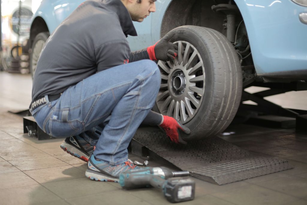 Mechaniker montiert ein Rad an einem Pkw