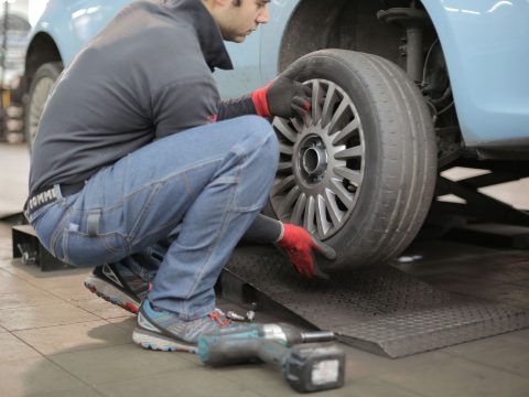 Mechaniker montiert ein Rad an einem Pkw